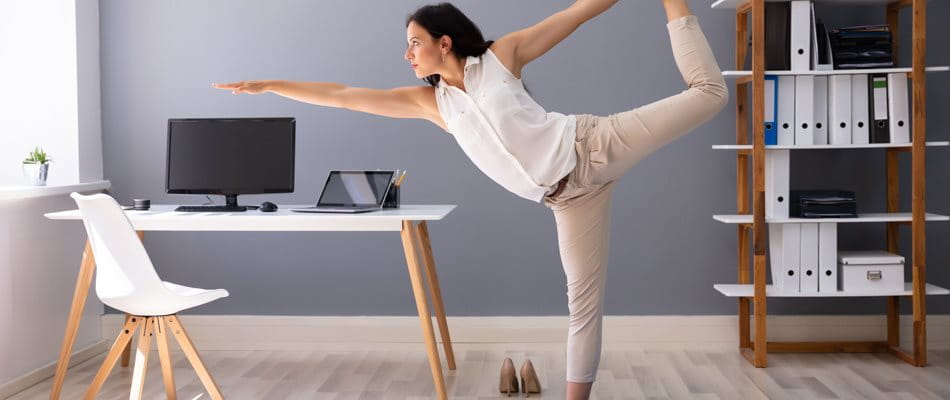 Une femme fait du yoga au bureau à domicile