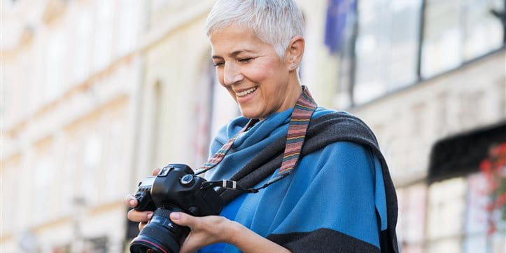 Femme dans une ville souriant à son appareil photo