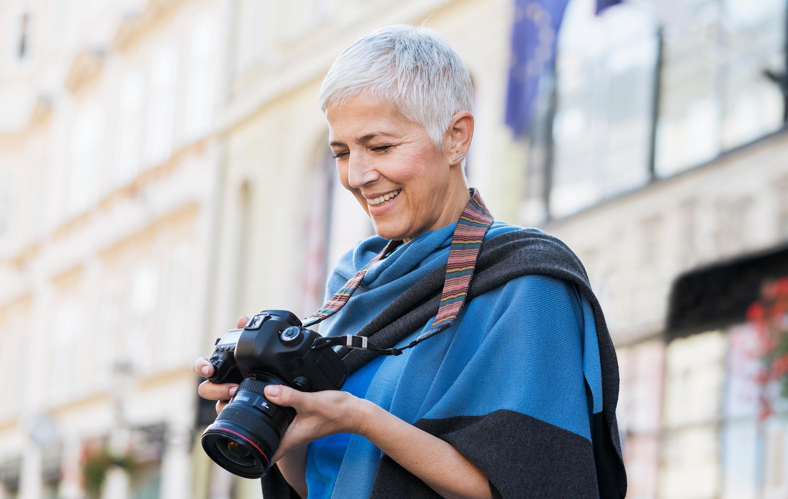Woman standing in a town smiling at her camera