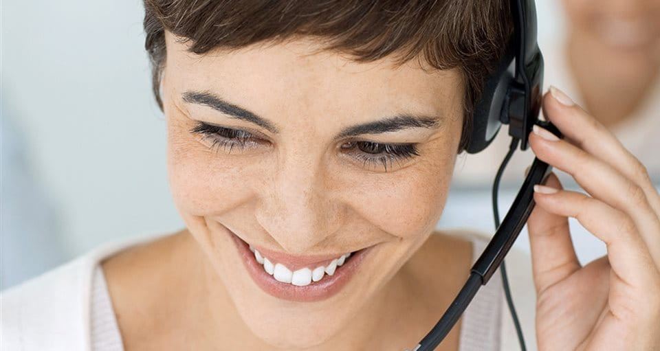 A smiling woman with short hair and a headset