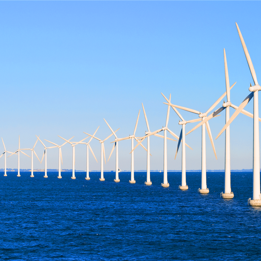 Several white wind turbines in the blue sea
