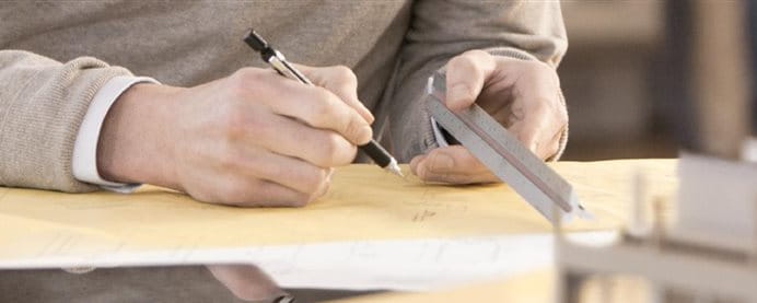 A man sketching on a desk.