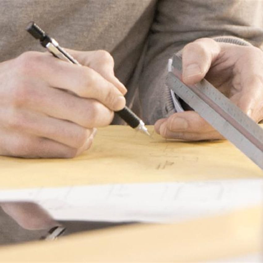 A man sketching on a desk.