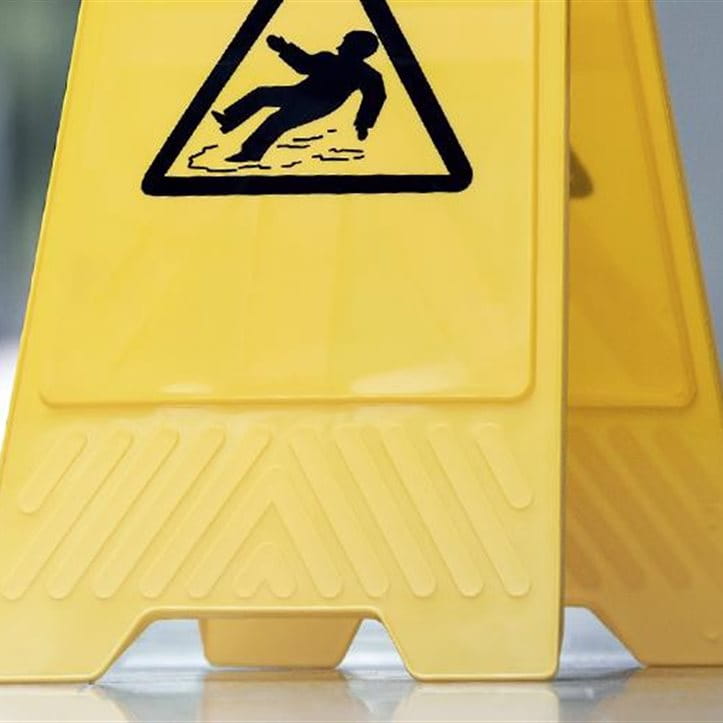 Eine gelbe Gefahrentafel steht auf dem Boden.
