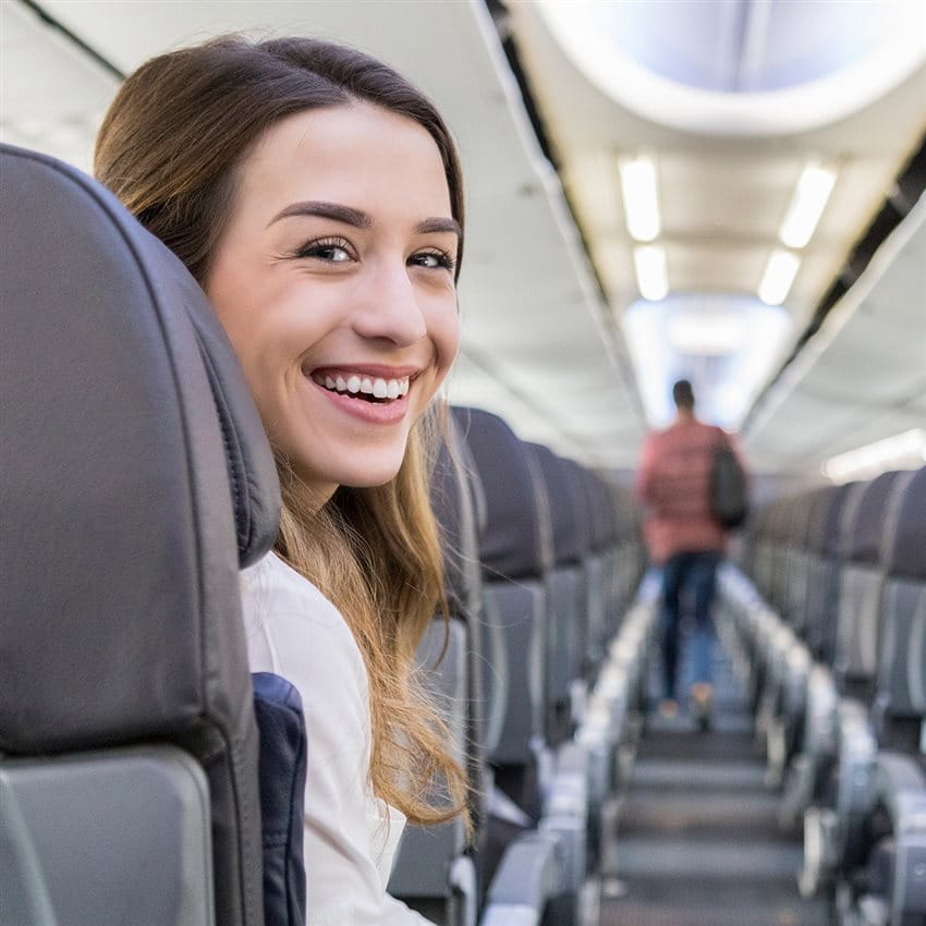 Frau lächelt im Flugzeug