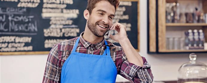 Phoning man in a blue apron