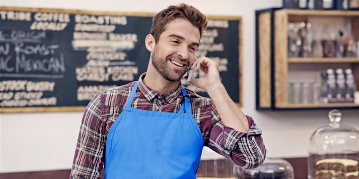 Phoning man in a blue apron