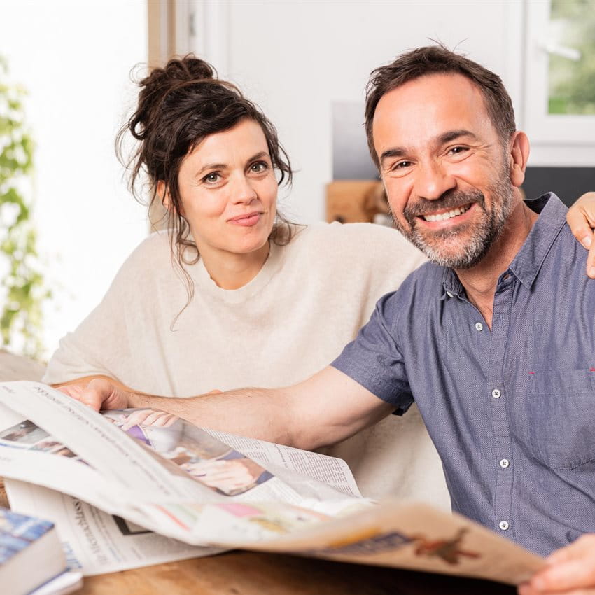 Donna e uomo che leggono il giornale al tavolo