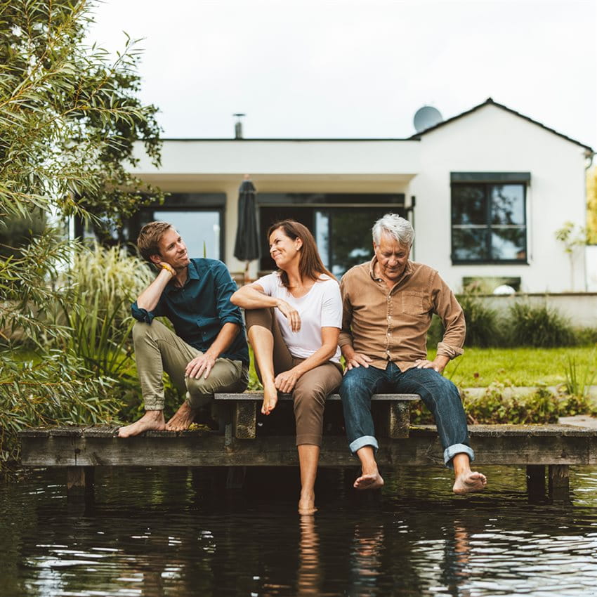 Couple with son at the waterfront of their family home