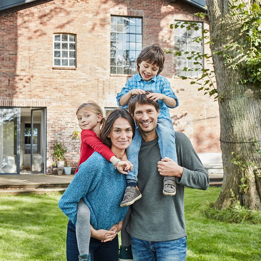 Coppia di famiglia con due bambini in giardino