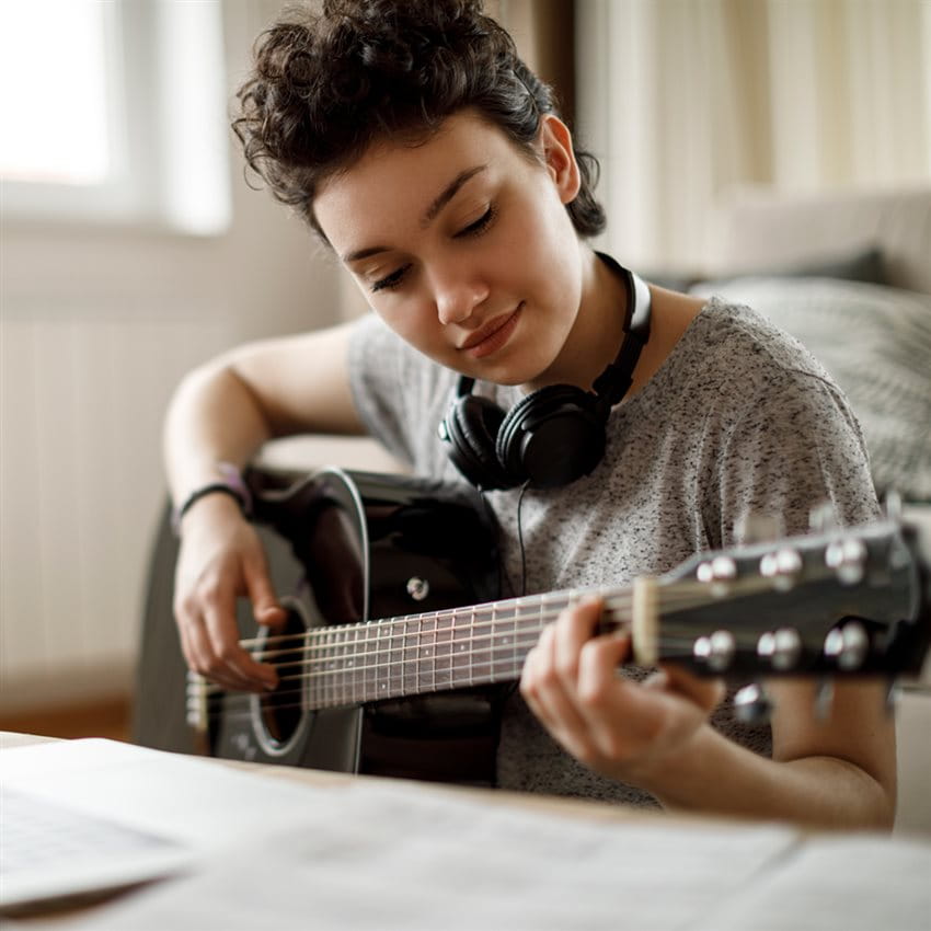 Jugendlicher spielt auf seiner wertvollen Gitarre