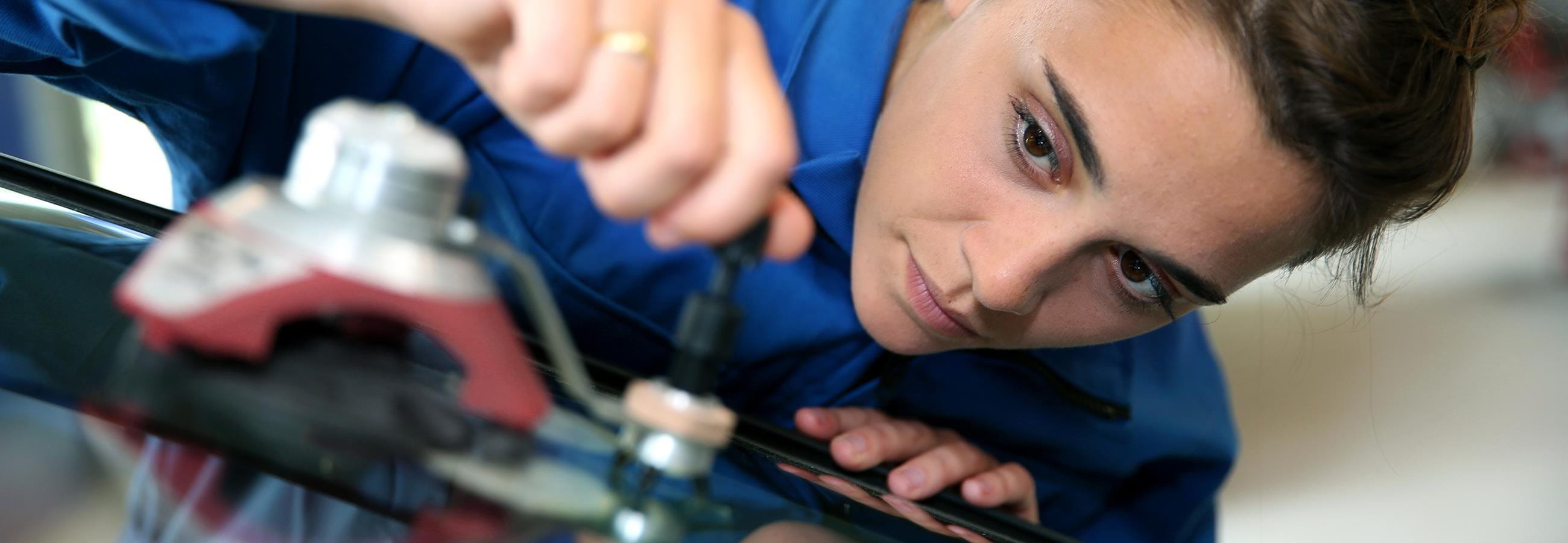 Frau repariert eine Glasscheibe