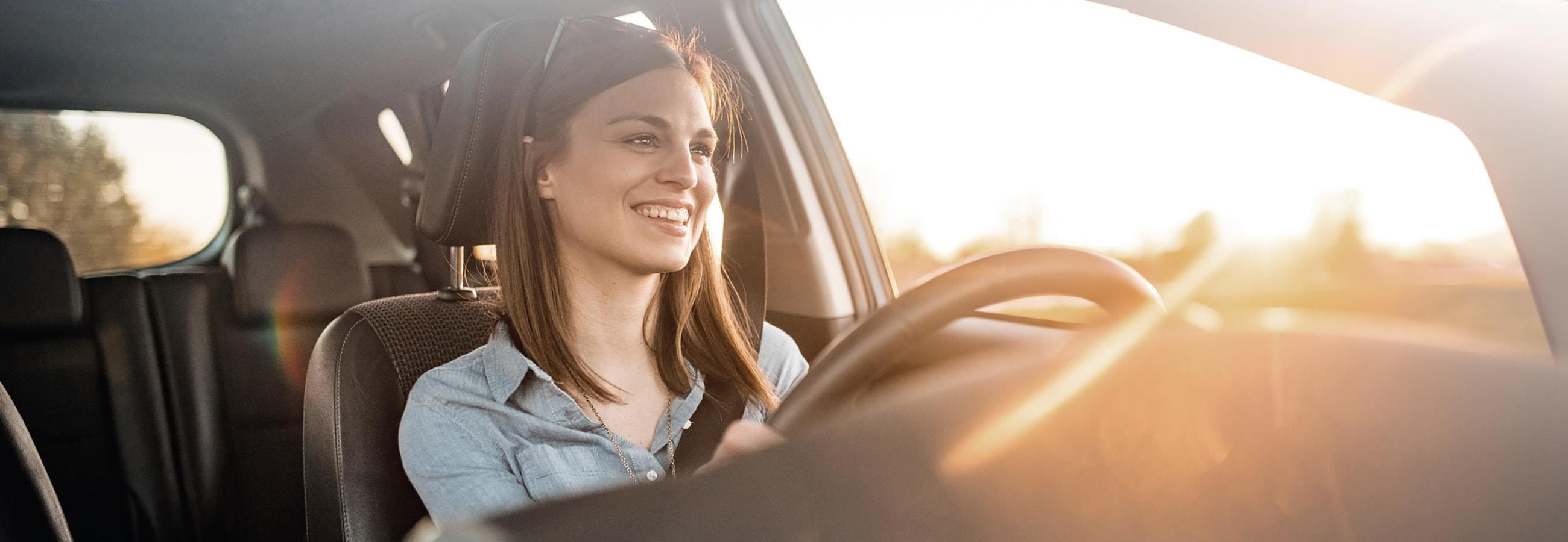 Giovane donna seduta al volante di una macchina
