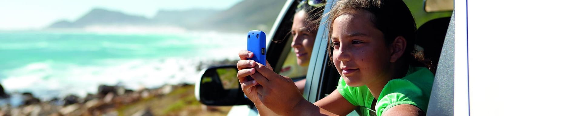 Child with cell phone in the car