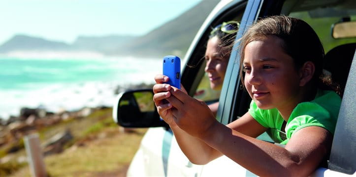 Child with cell phone in the car