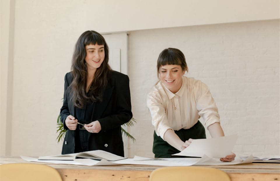Two women looking over documents in an office