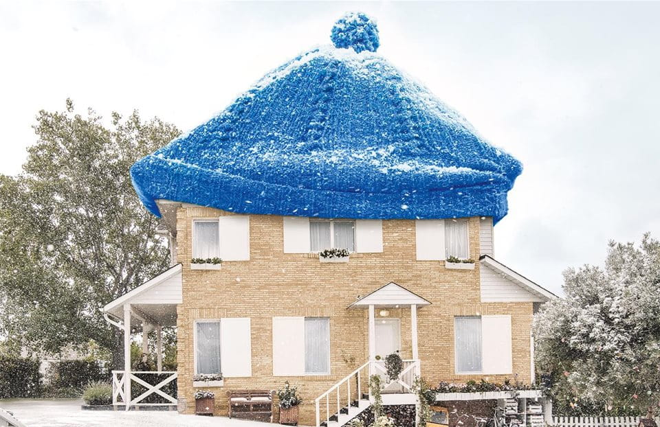 Maison au chapeau bleu dans un paysage enneigé