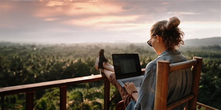 Une femme travaille avec un ordinateur portable sur la terrasse