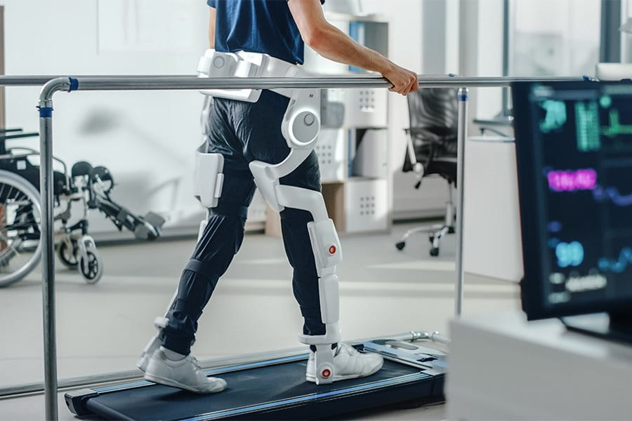 A woman wearing leg braces on a treadmill