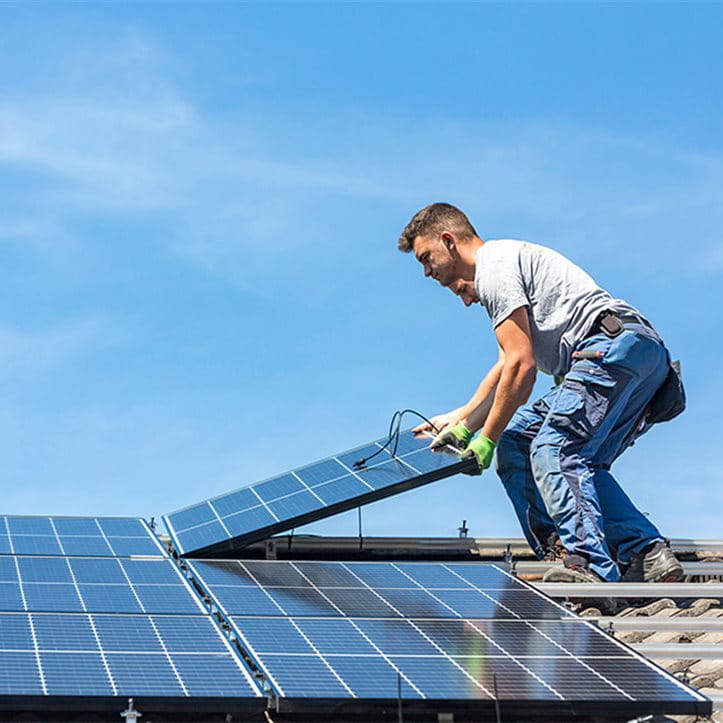 Mann montiert Solarpanel auf Dach