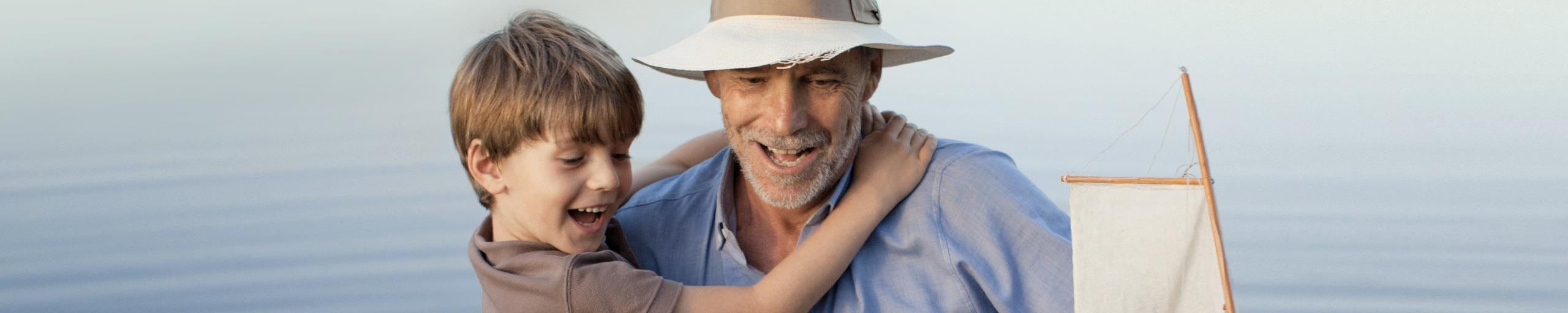 A boy in the arms of an elderly man.